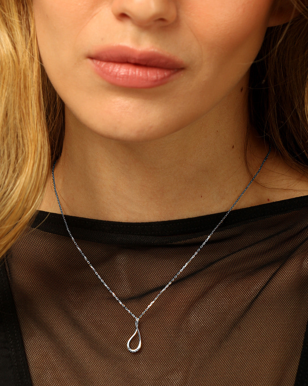 collar de mujer plateado puesto en el cuello de una mujer